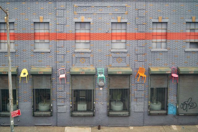 A photo of chairs hanging off the side of a building in Brooklyn